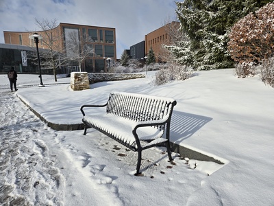 Snow on a bench near the fountain at RIT
